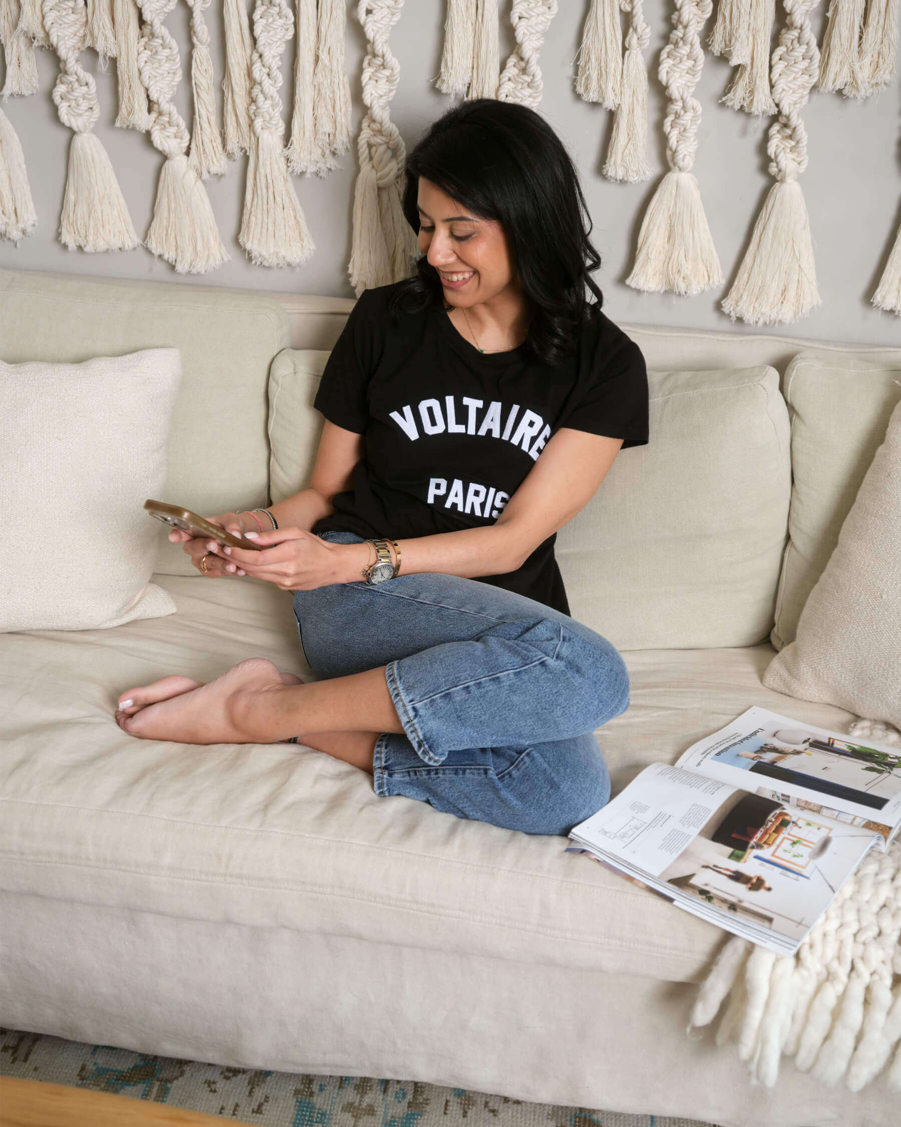 Nikhita, a wellness brand strategist on the sofa working on her phone 